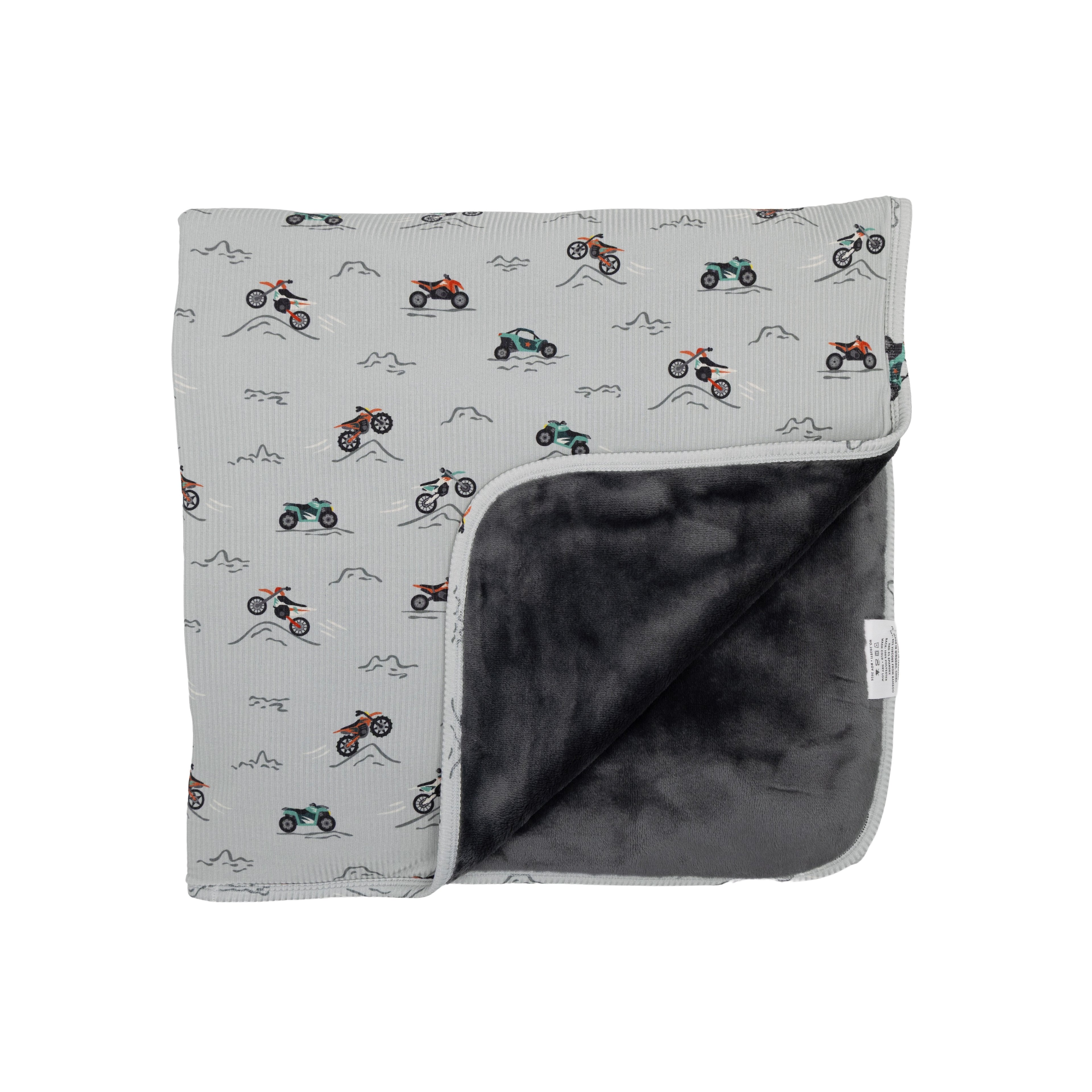 Blanket with motorcycle pattern on one side and solid color on the other, on a white background