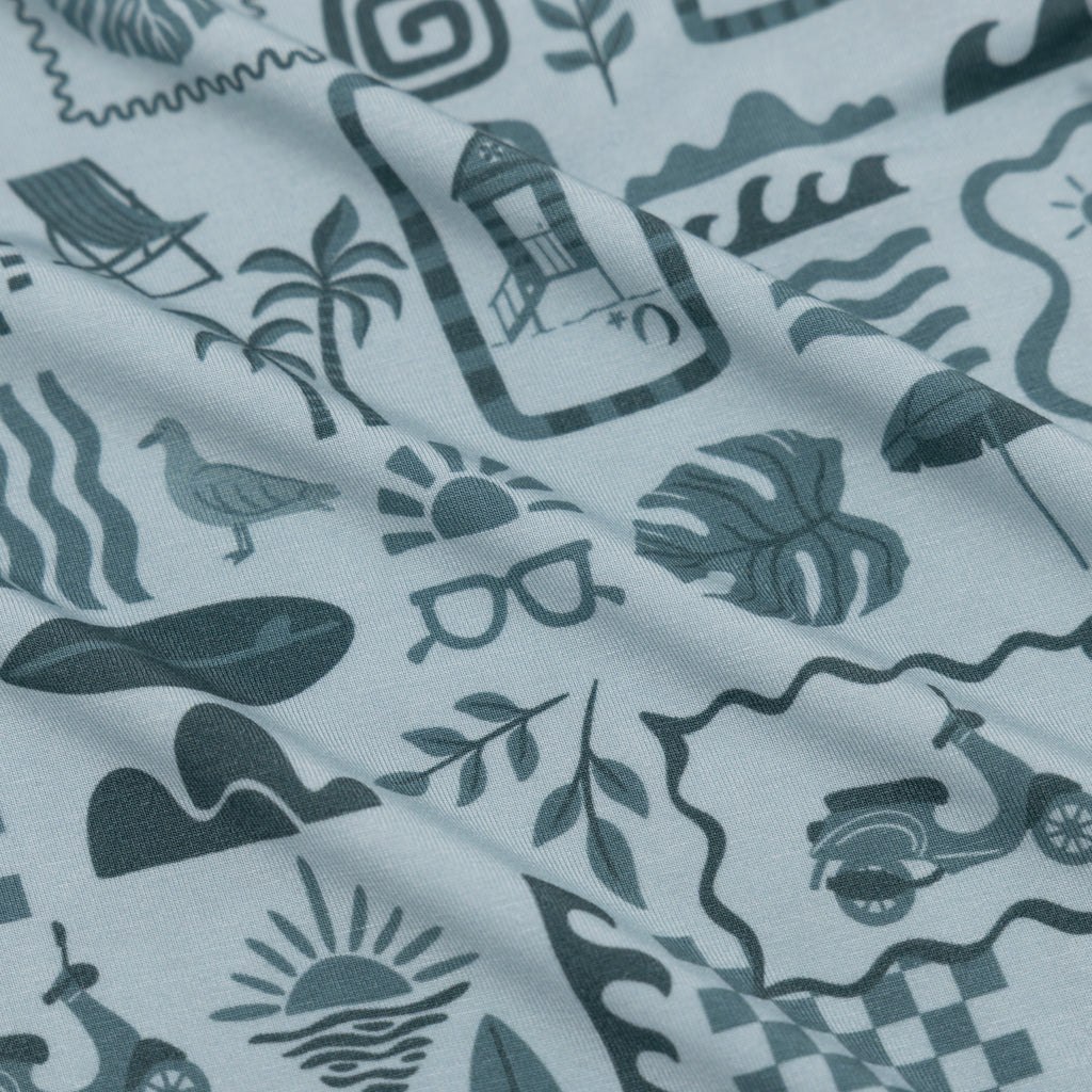 Fabric with a pattern of summer icons and symbols on a white background