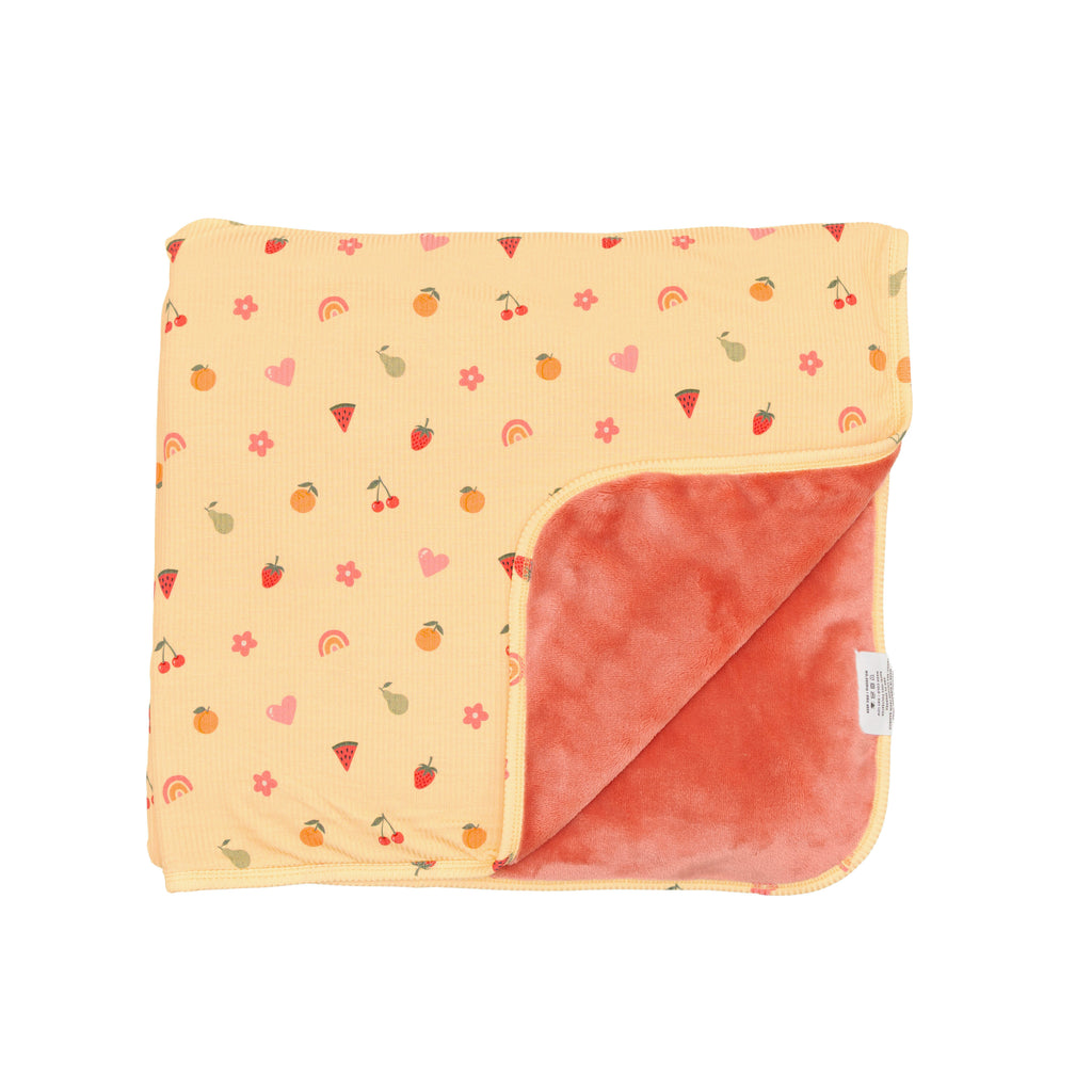 Baby blanket with colorful fruit pattern on one side and solid color on the other, on a white background.