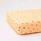 Yellow fruity-patterned fitted sheet on a white background