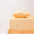 Wooden bed with a yellow pillow and matching bedding on a white background