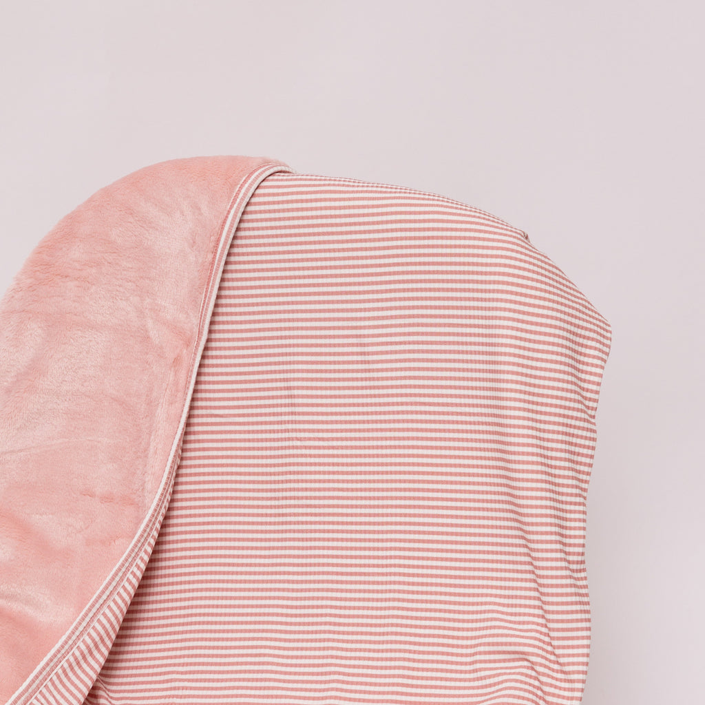 Pink striped blanket draped over a chair on a white background