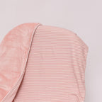 Pink striped blanket draped over a chair on a white background