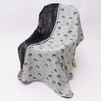 Blanket with off-road vehicle pattern draped over a chair on a white background