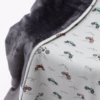 Close up shot of a blanket with off-road vehicle pattern draped over a chair on a white background