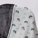 Close up shot of a blanket with off-road vehicle pattern draped over a chair on a white background