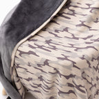 Close up of a camouflage-patterned blanket with dark backing draped on a chair