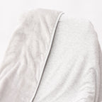 Close up of a gray blanket draped over a wooden chair on a white background