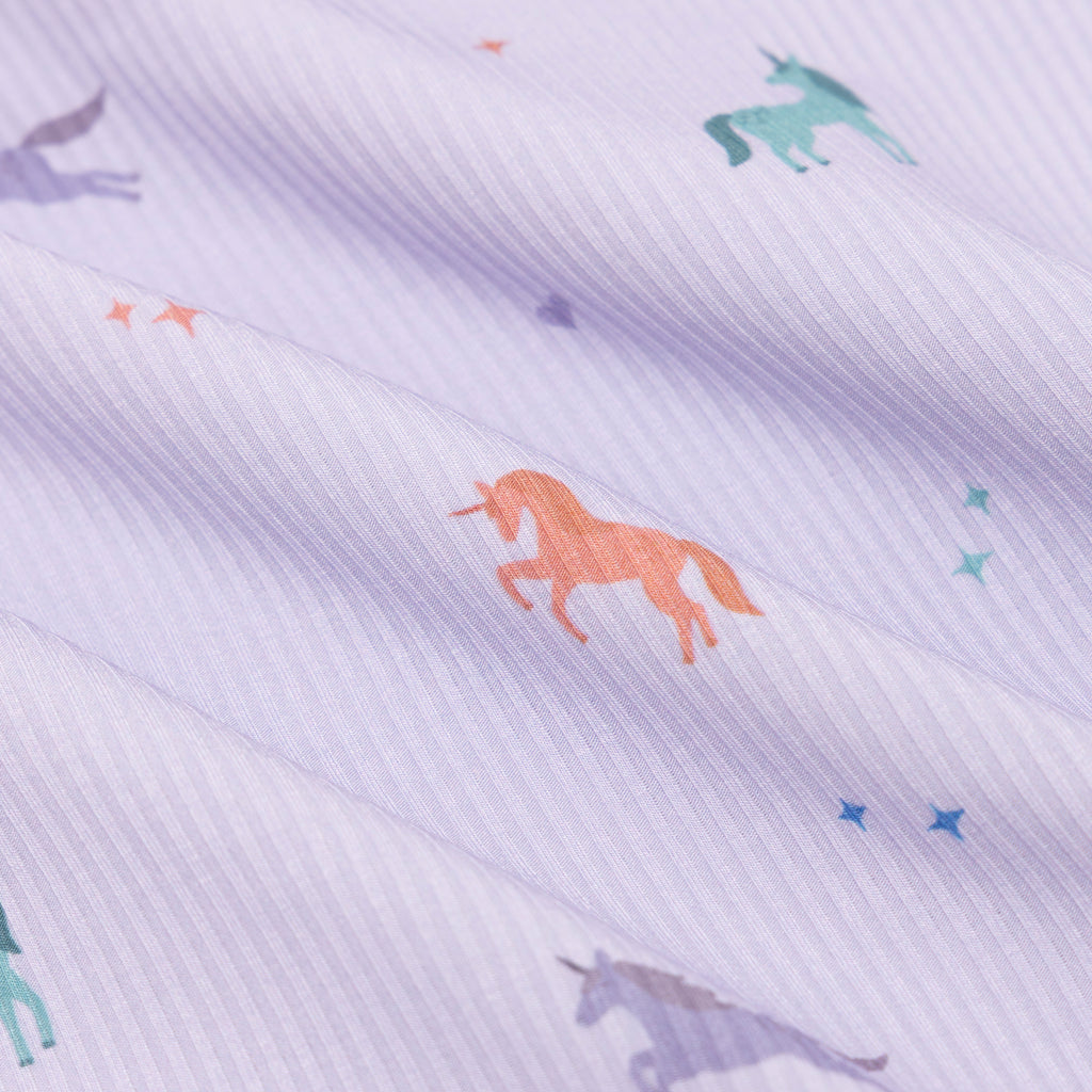 Fabric with colorful unicorn pattern on a light purple background