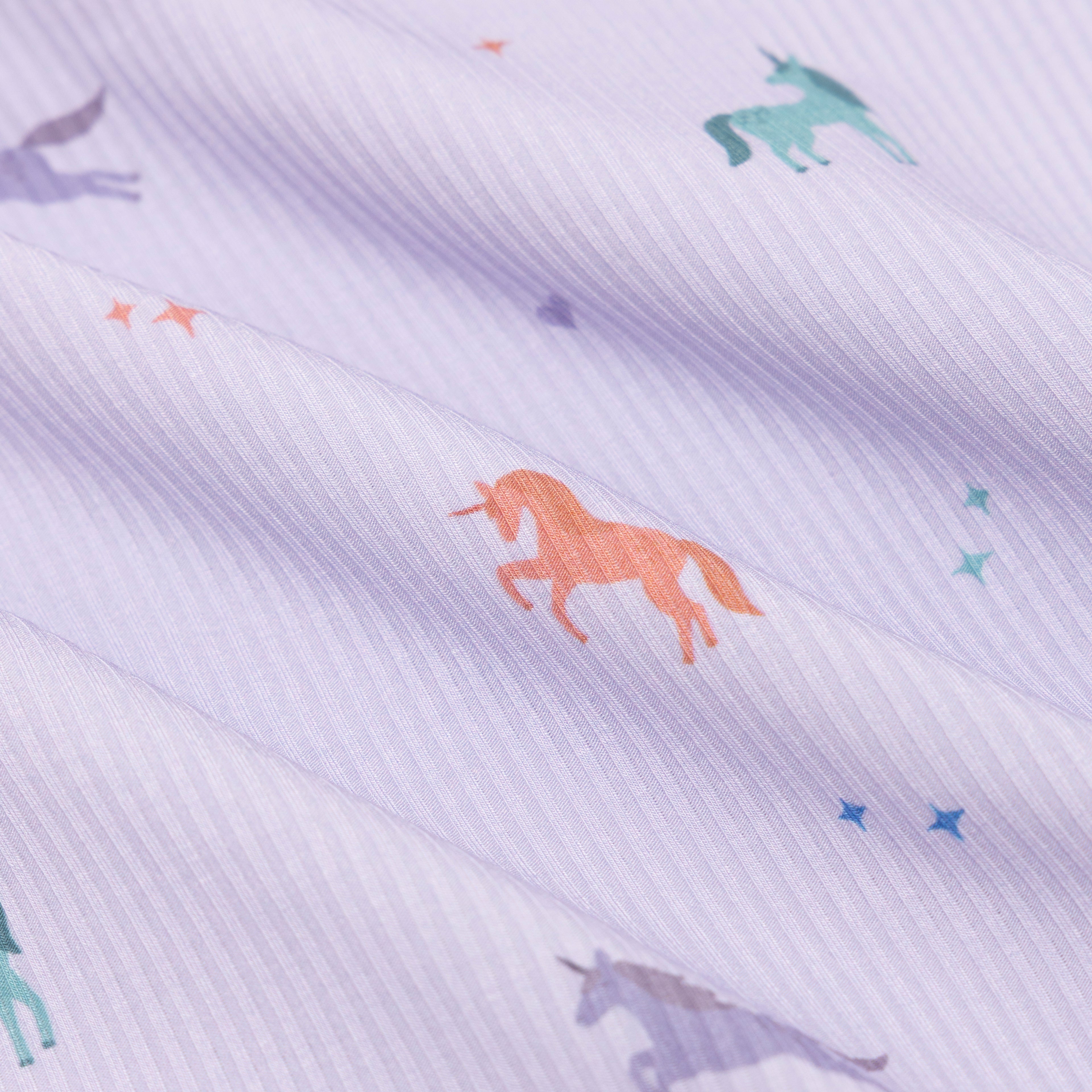 Fabric with colorful unicorn pattern on a light purple background