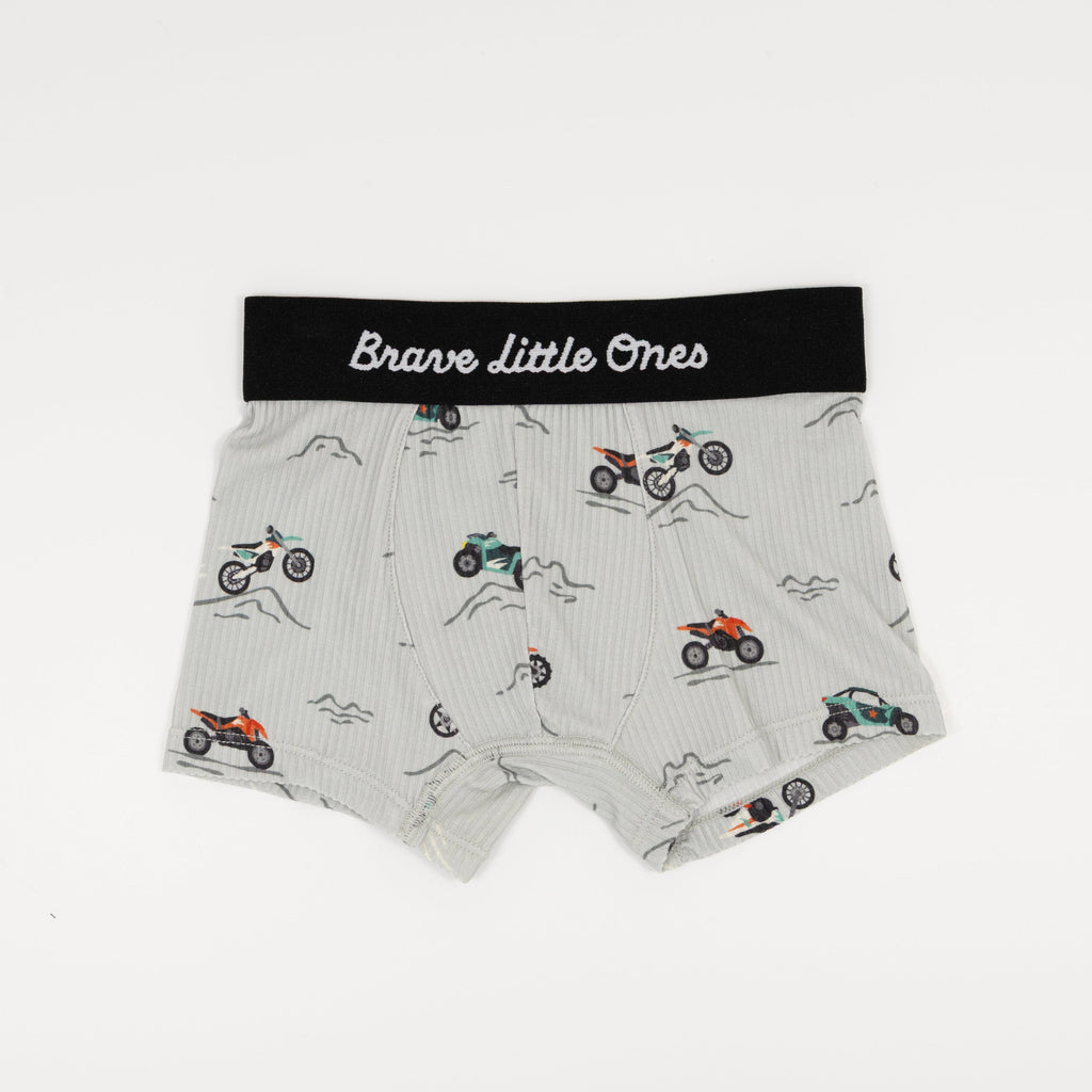 Children's underwear with dirt bike pattern and 'Brave Little Ones' label on a white background