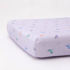 Fitted crib sheet with colorful unicorn patterns on a white background
