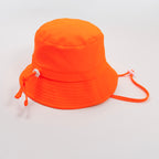 Orange bucket hat with a strap on a plain background