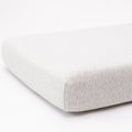 Gray fitted sheet on a mattress with a white background