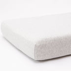 Gray fitted sheet on a mattress with a white background