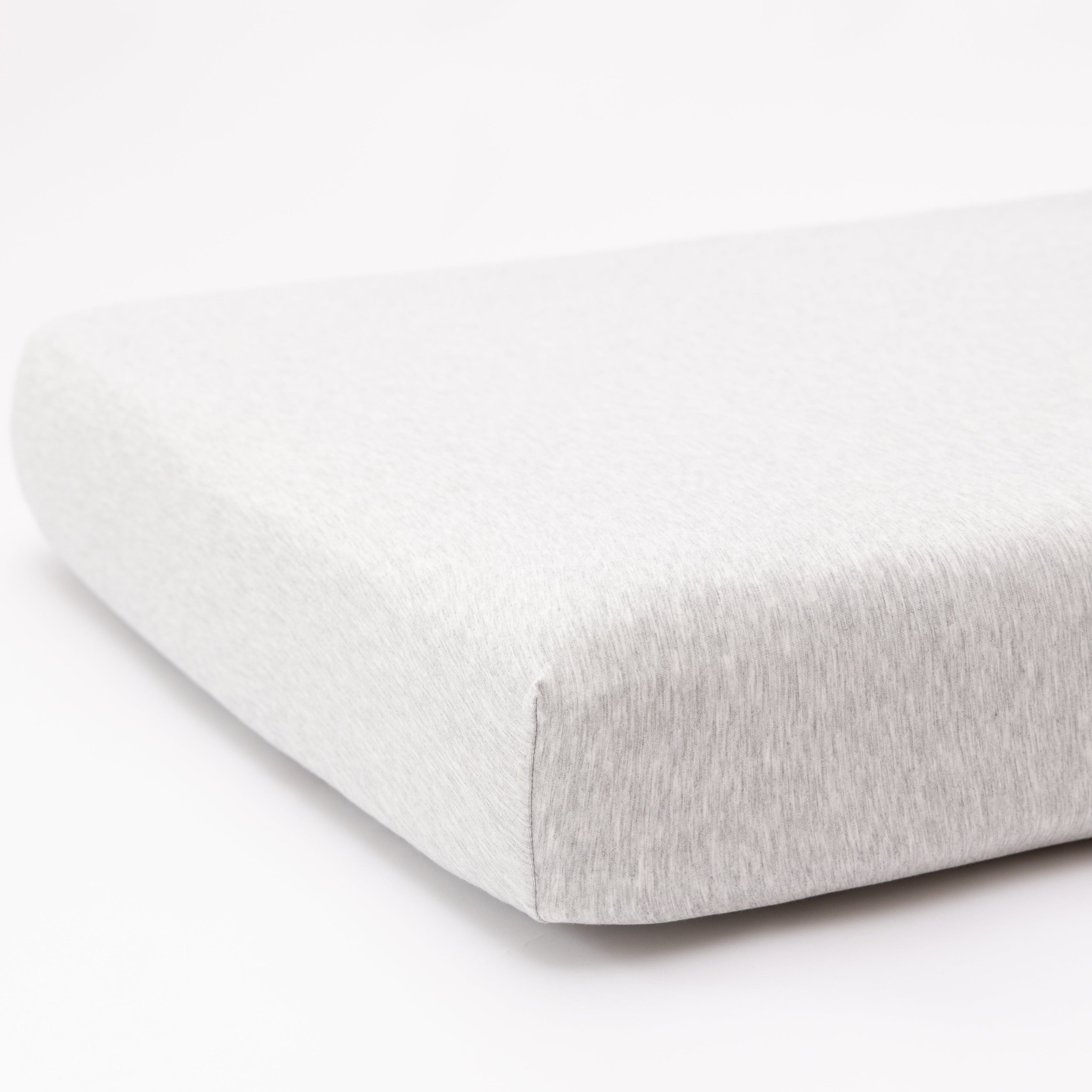 Gray fitted sheet on a mattress with a white background