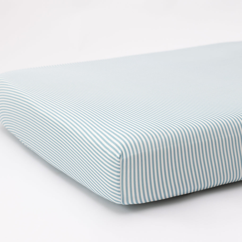 Striped fitted sheet on a mattress with a white background