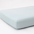Striped fitted sheet on a mattress with a white background