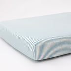 Striped fitted sheet on a mattress with a white background