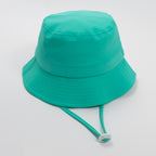 Turquoise bucket hat with a strap on a plain background