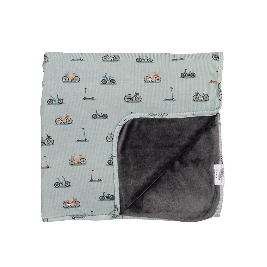 Children's blanket with bicyles & scooters pattern on a white background