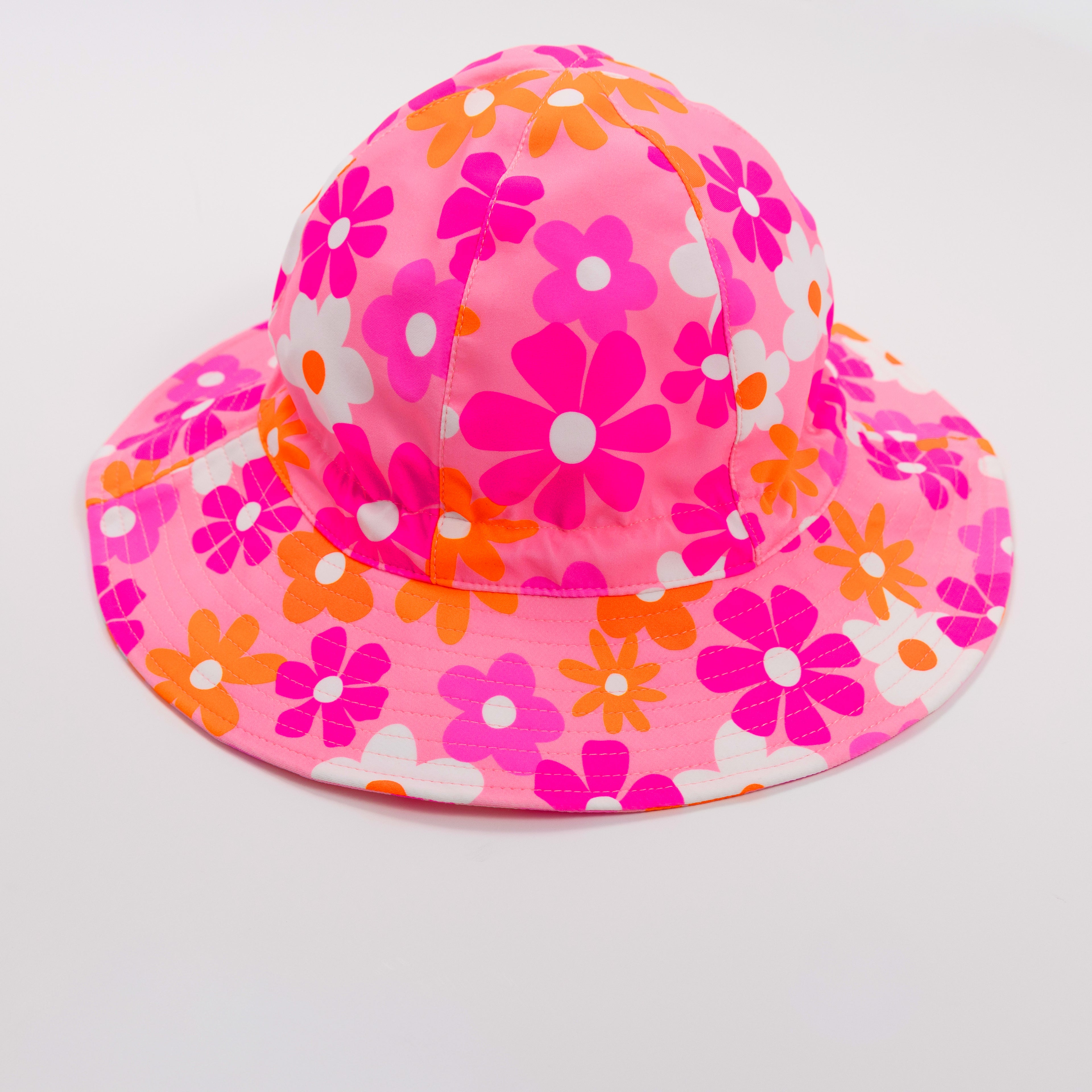 Floral patterned sun hat with a strap on a plain background