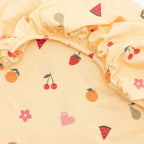 Yellow fabric with fruit and heart patterns on a white background