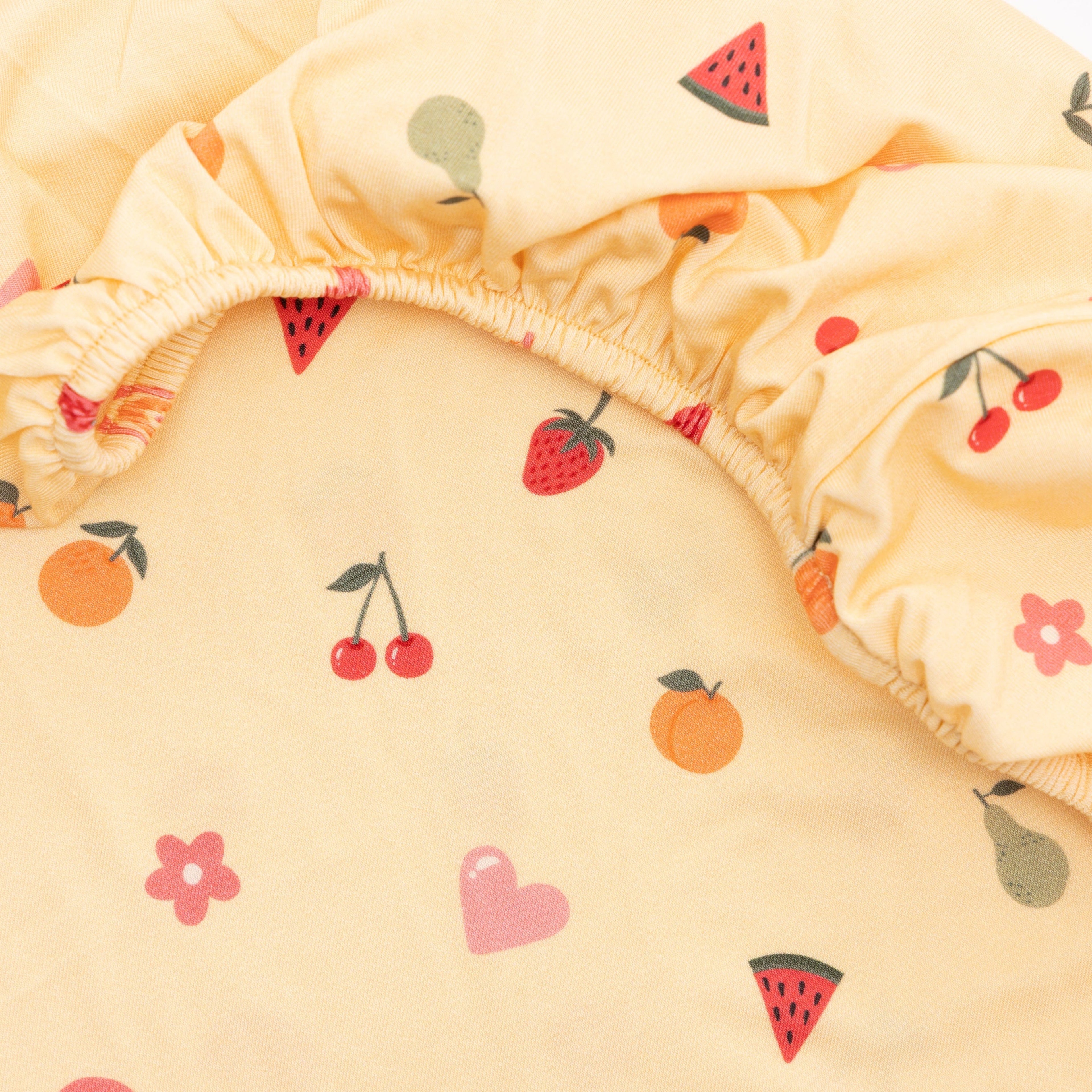 Yellow fabric with fruit and heart patterns on a white background