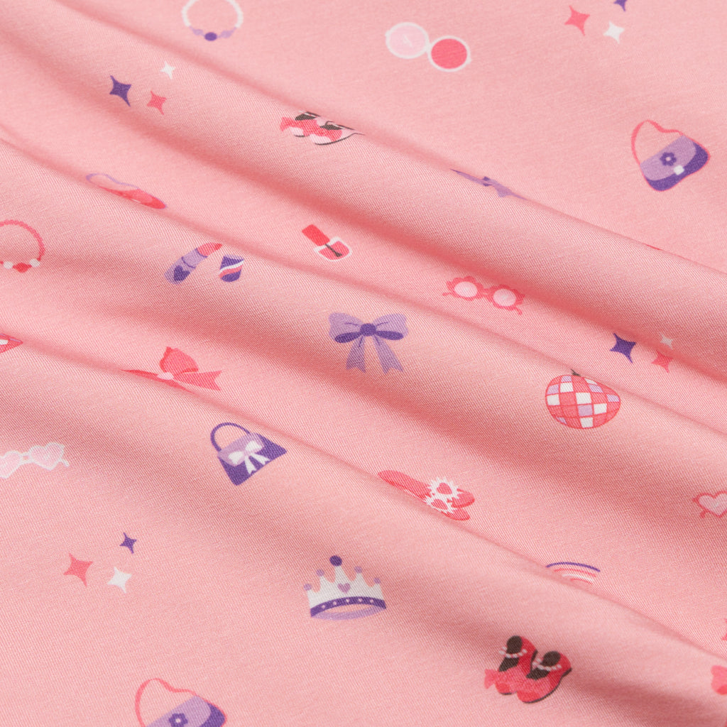 Pink fabric with small colorful patterns including bows and hats.
