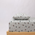 Twin-sized bed with a vehicle patterned bedding and pillow on a white background