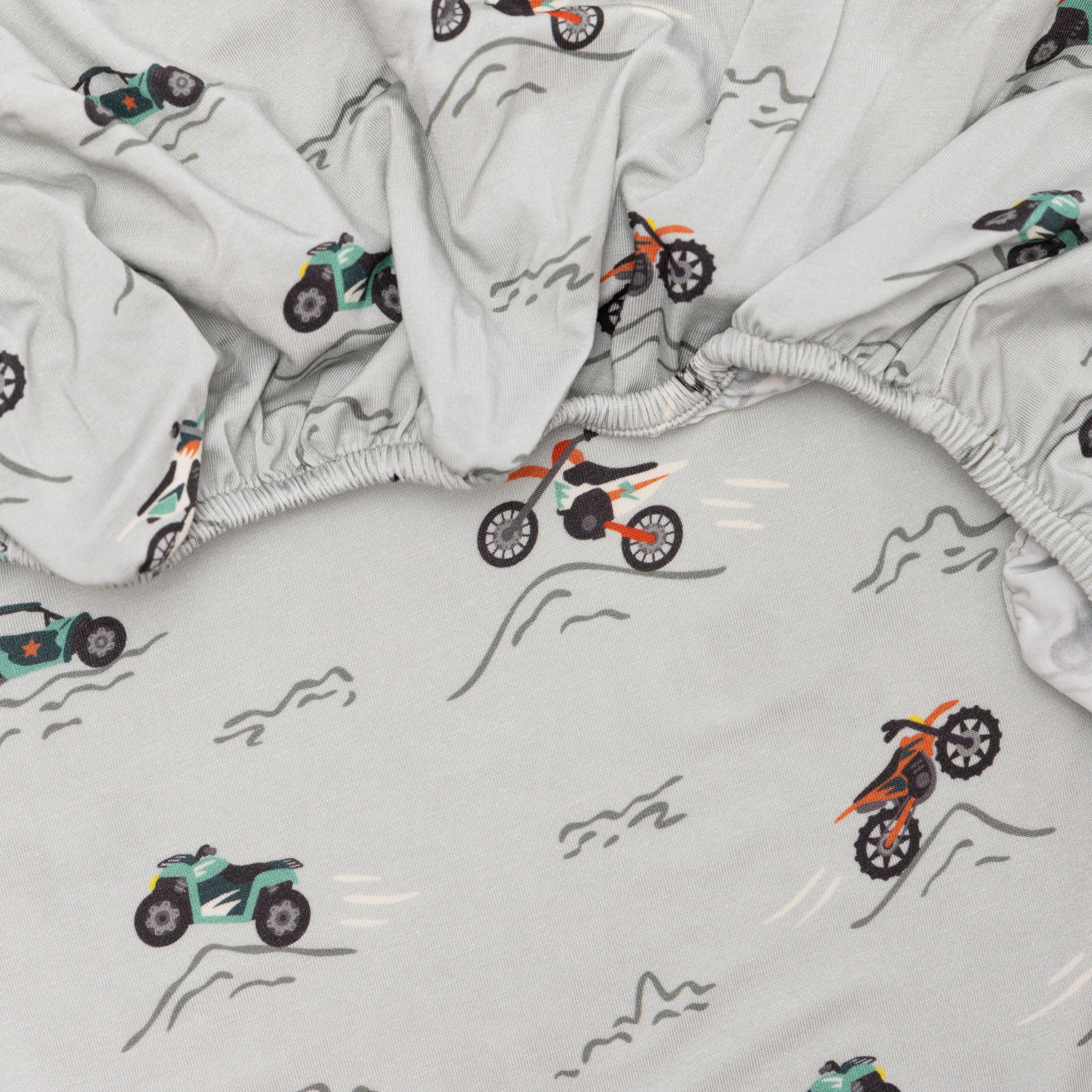 Close up shot of a fitted crib sheet with dirt bike pattern