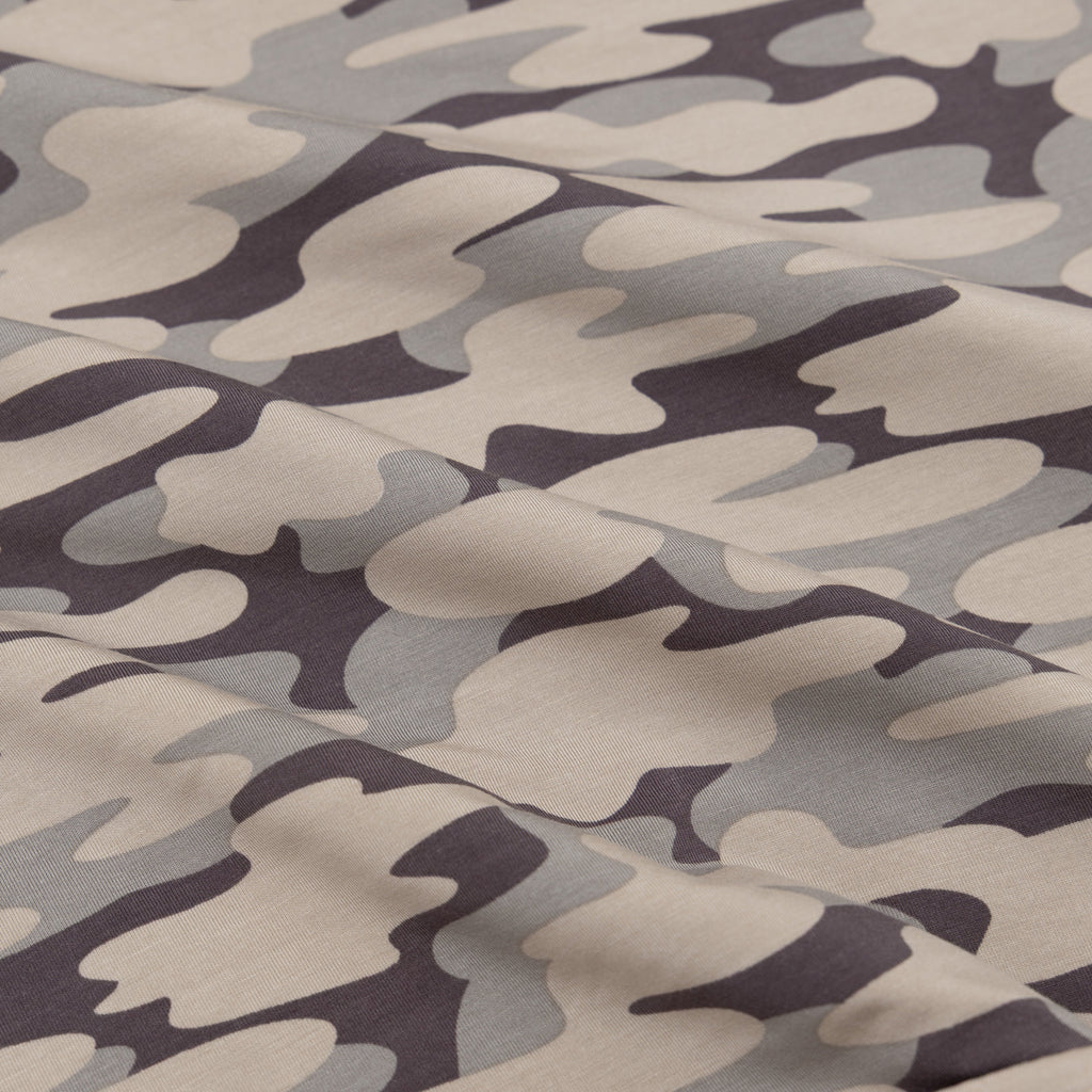 Camouflage pattern fabric in shades of brown, gray, and black.
