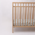 Fitted crib sheet with dirt bike pattern on a wooden crib with mattress