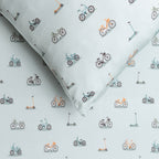 Fabric with small bike and scooter patterns on a light blue background