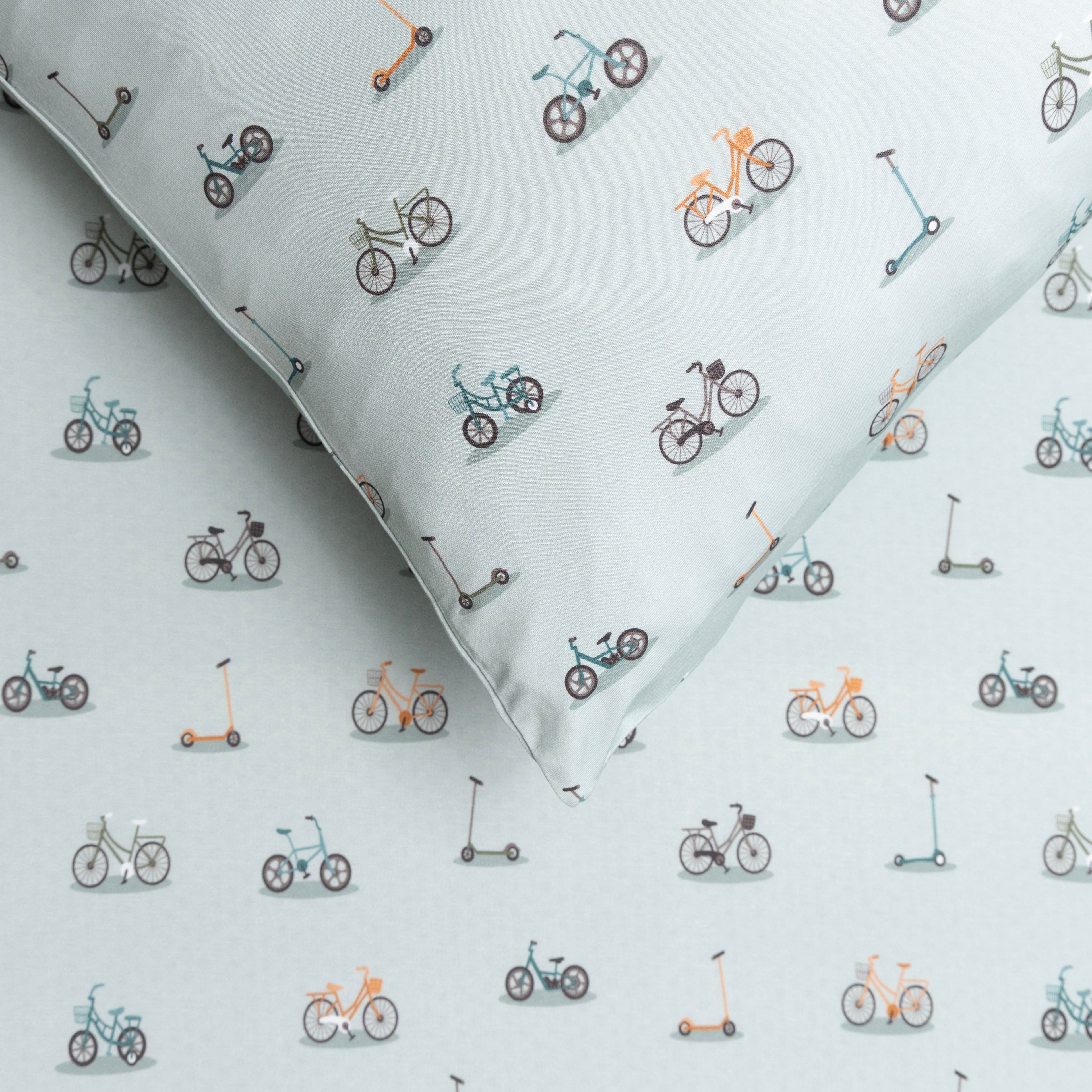 Fabric with small bike and scooter patterns on a light blue background