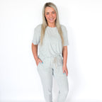 Woman wearing a light gray pajama set on a white background
