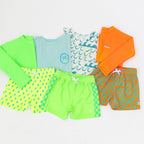 Collection of colorful children's swimwear and summer daywear on a white background