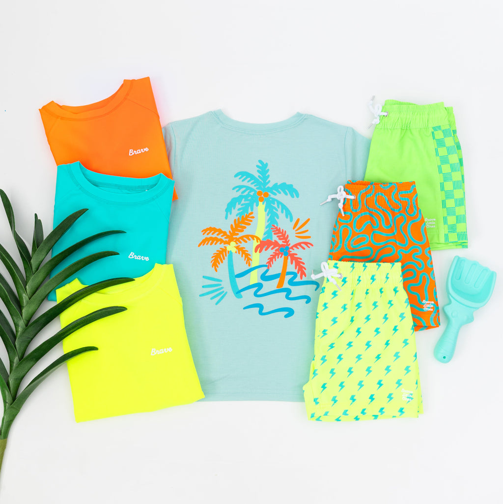 Collection of colorful children's swimwear and summer daywear on a white background