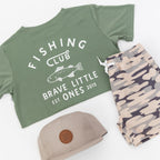 Green t-shirt with 'Fishing Club' text, taupe cap, and camouflage shorts on a white background
