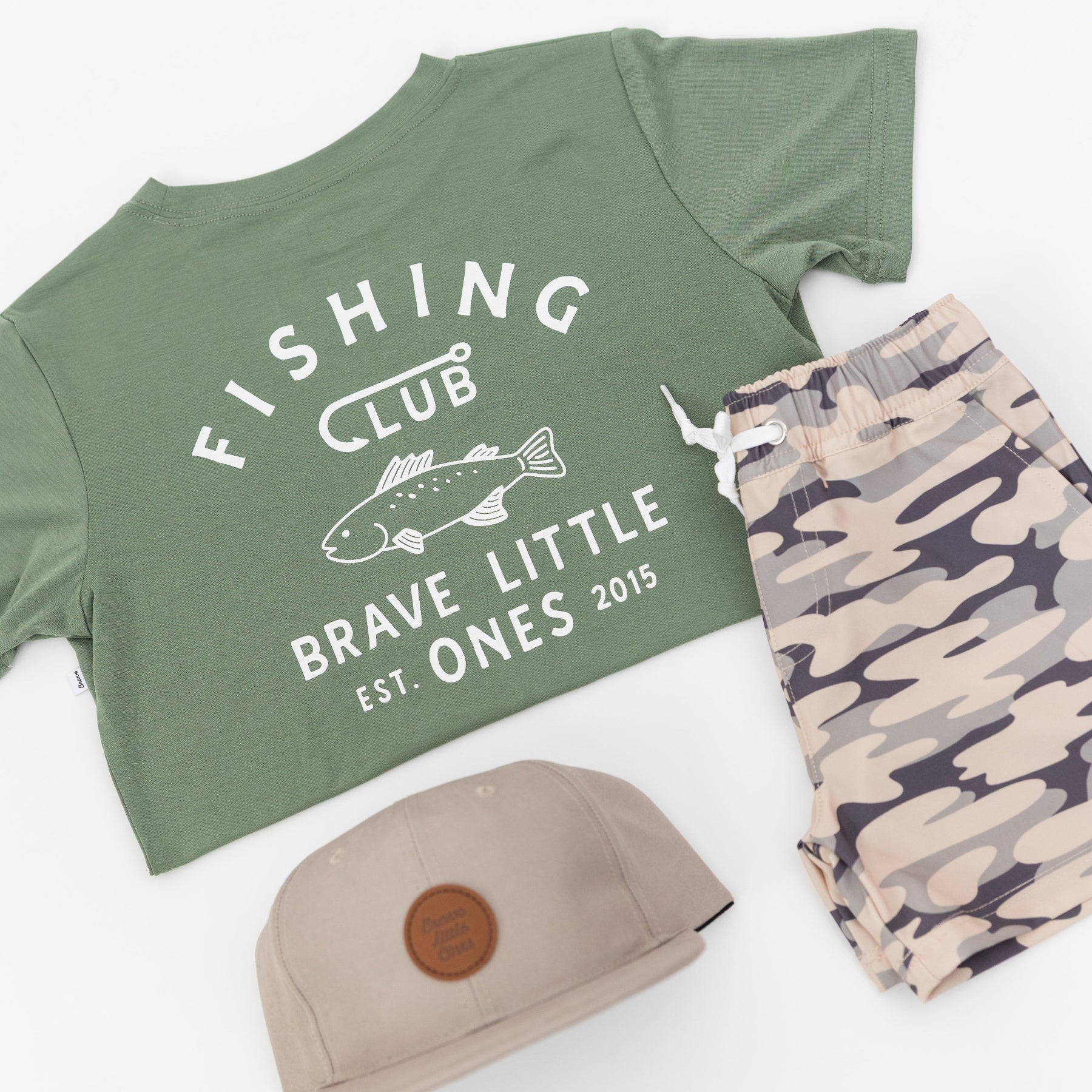 Green t-shirt with 'Fishing Club' text, taupe cap, and camouflage shorts on a white background