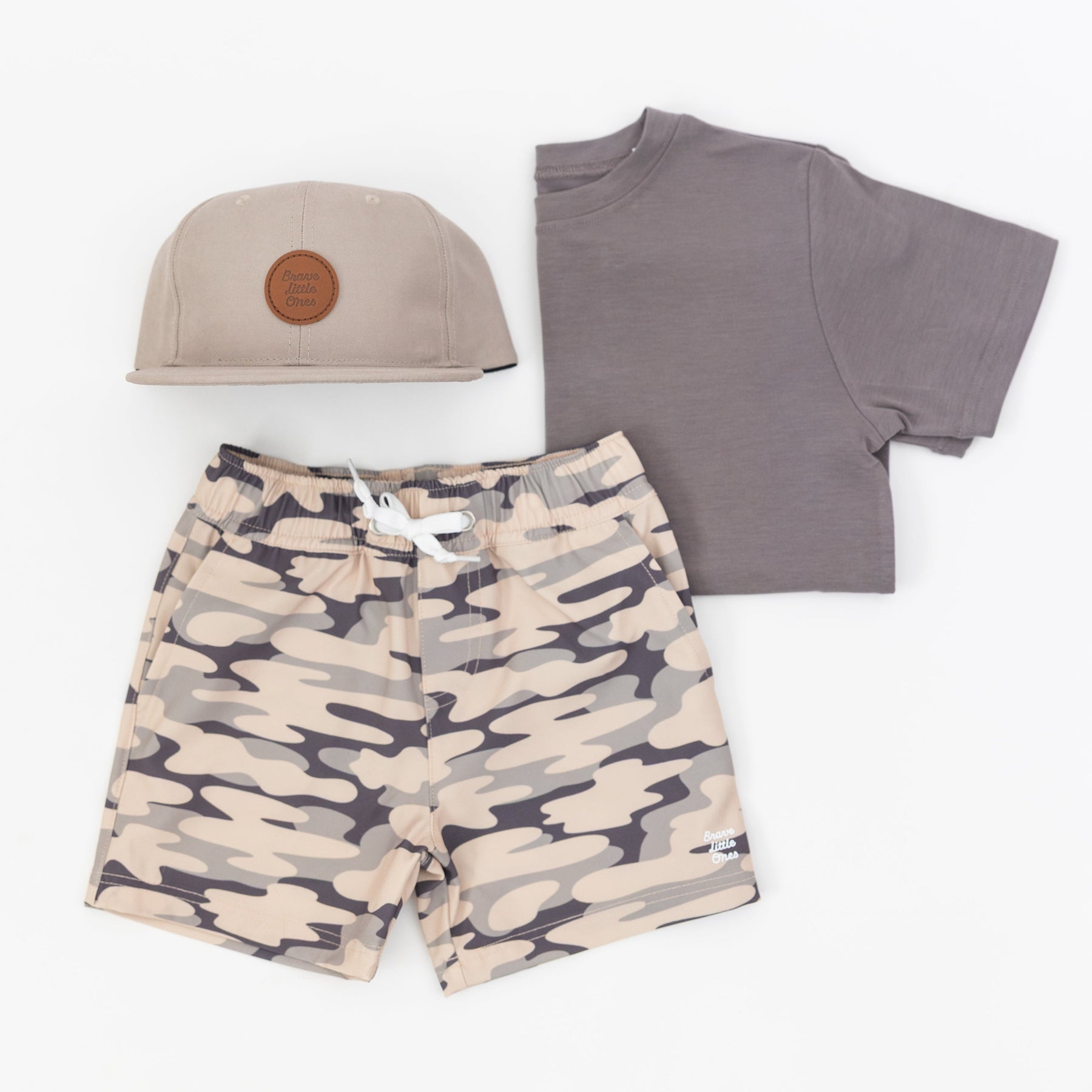 Children's outfit with camouflage shorts, gray t-shirt, and taupe cap on a white background