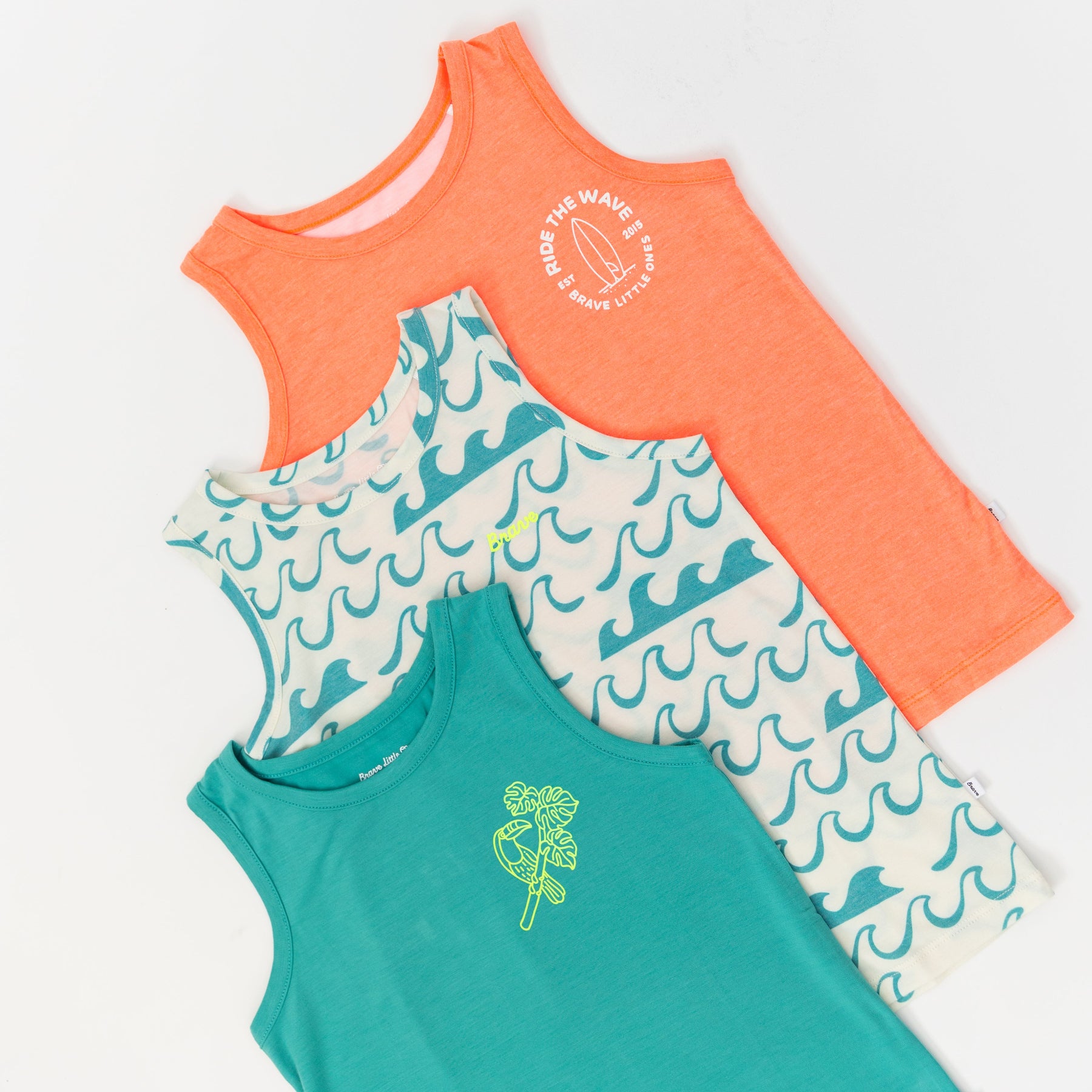 Three children's tank tops in orange, turquoise, and white with wave pattern on a white background