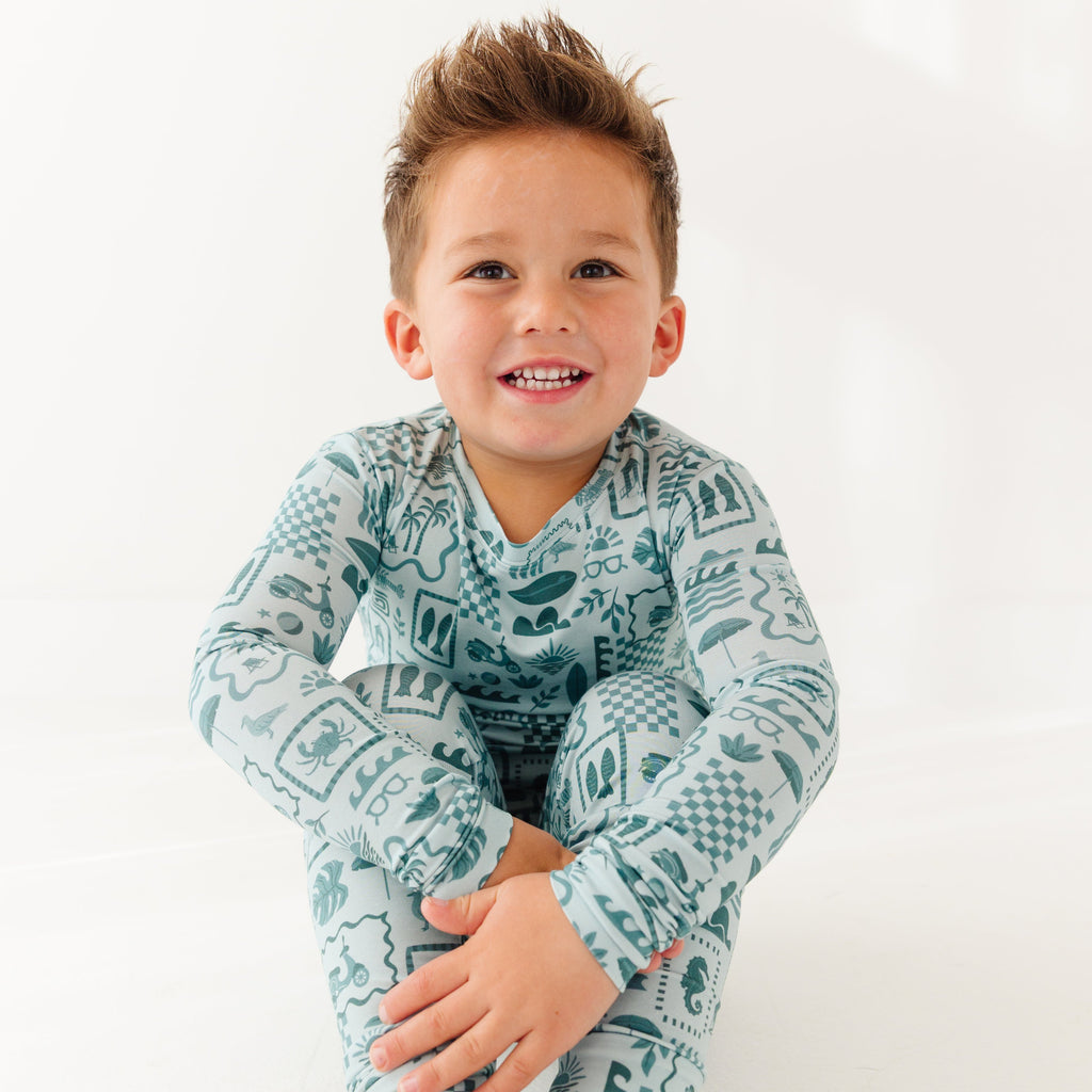 Child wearing a blue summer-patterned pajama set on a white background