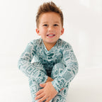 Child wearing a blue summer-patterned pajama set on a white background