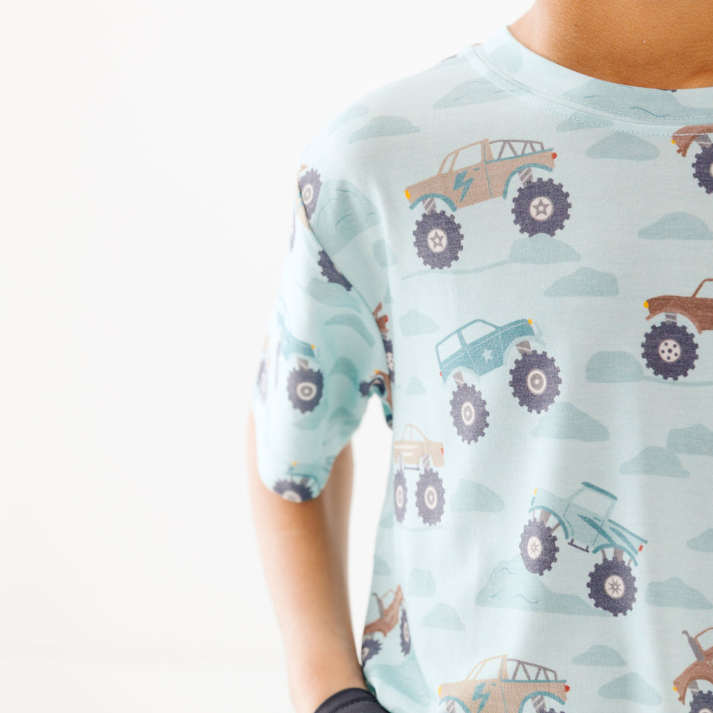 Close up shot of a light blue t-shirt with vehicle pattern on a white background