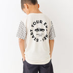 Child wearing a white t-shirt with text and checkered sleeves on a white background