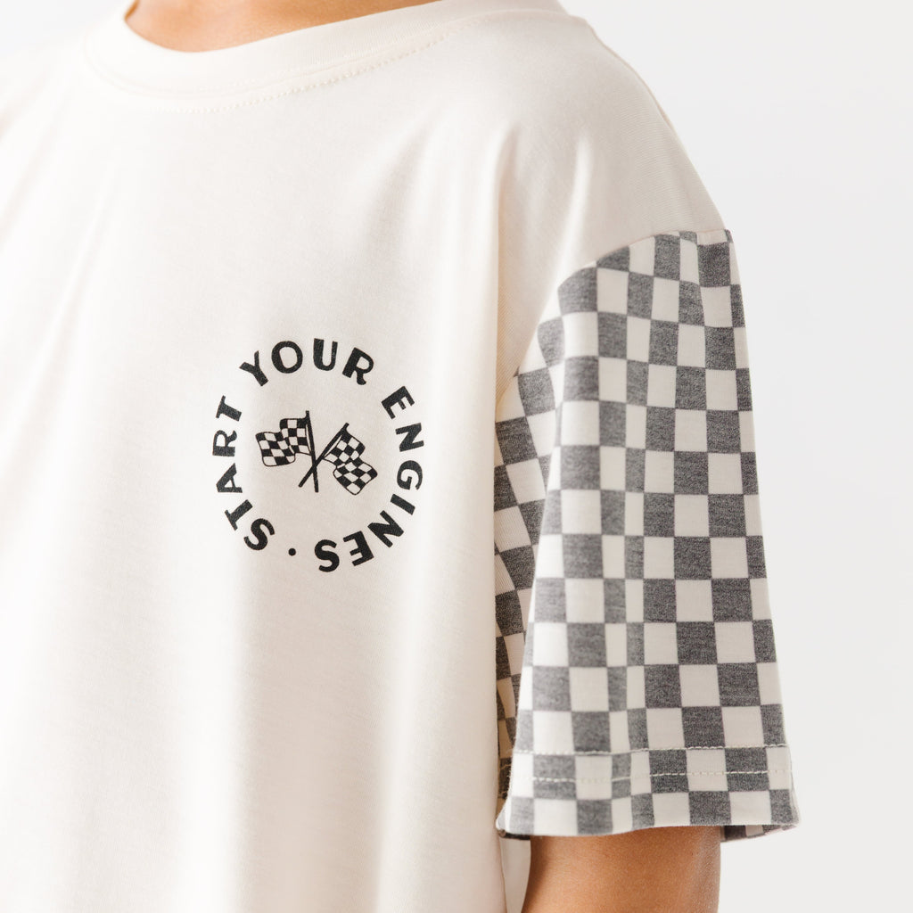 Close up shot of a white t-shirt with checkered sleeves on a white background