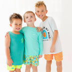 Three children wearing colorful brave little ones swimwear standing together on a white background