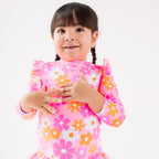 Child wearing a pink floral one-piece swimsuit on a white background