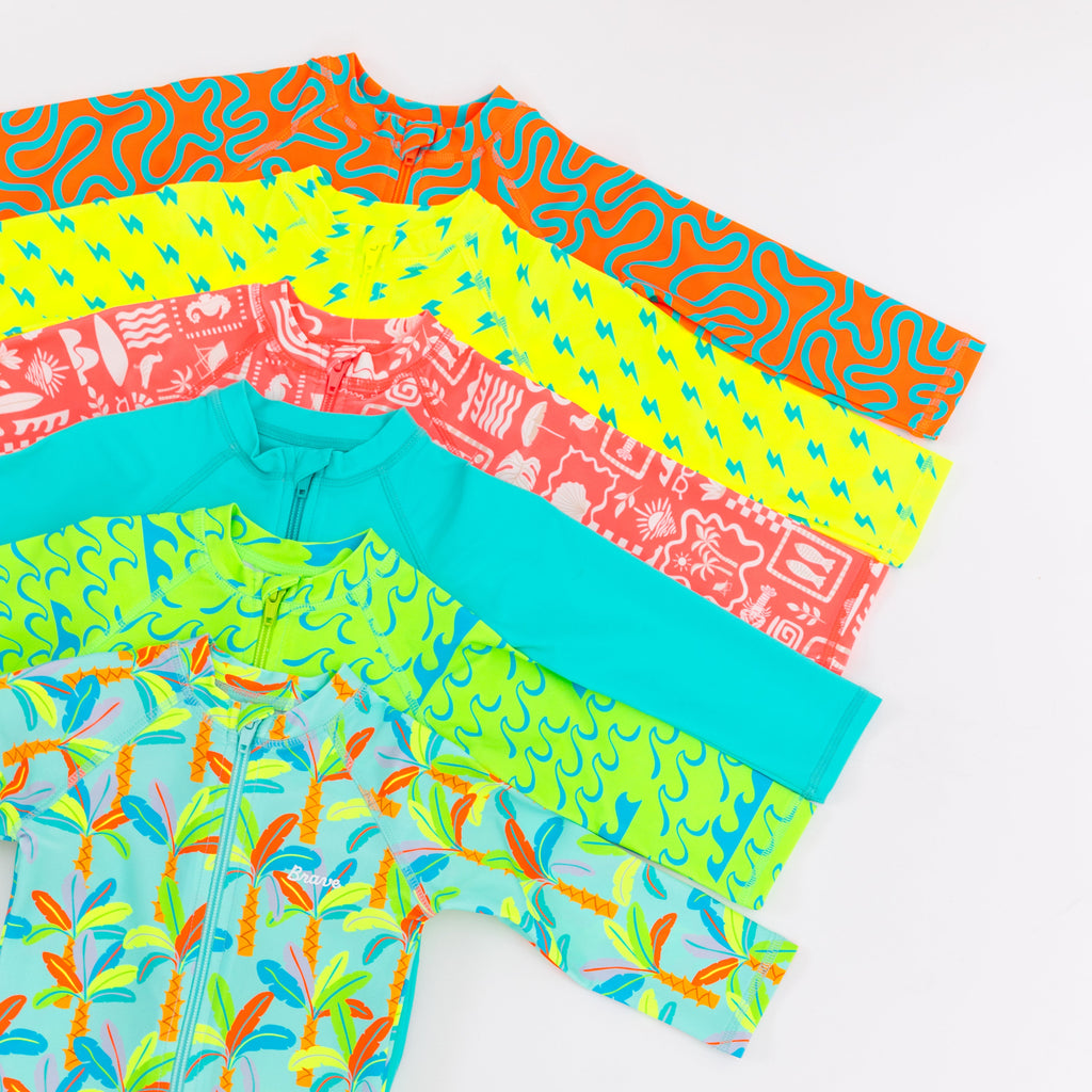 Colorful boy swimsuits stacked on a white background